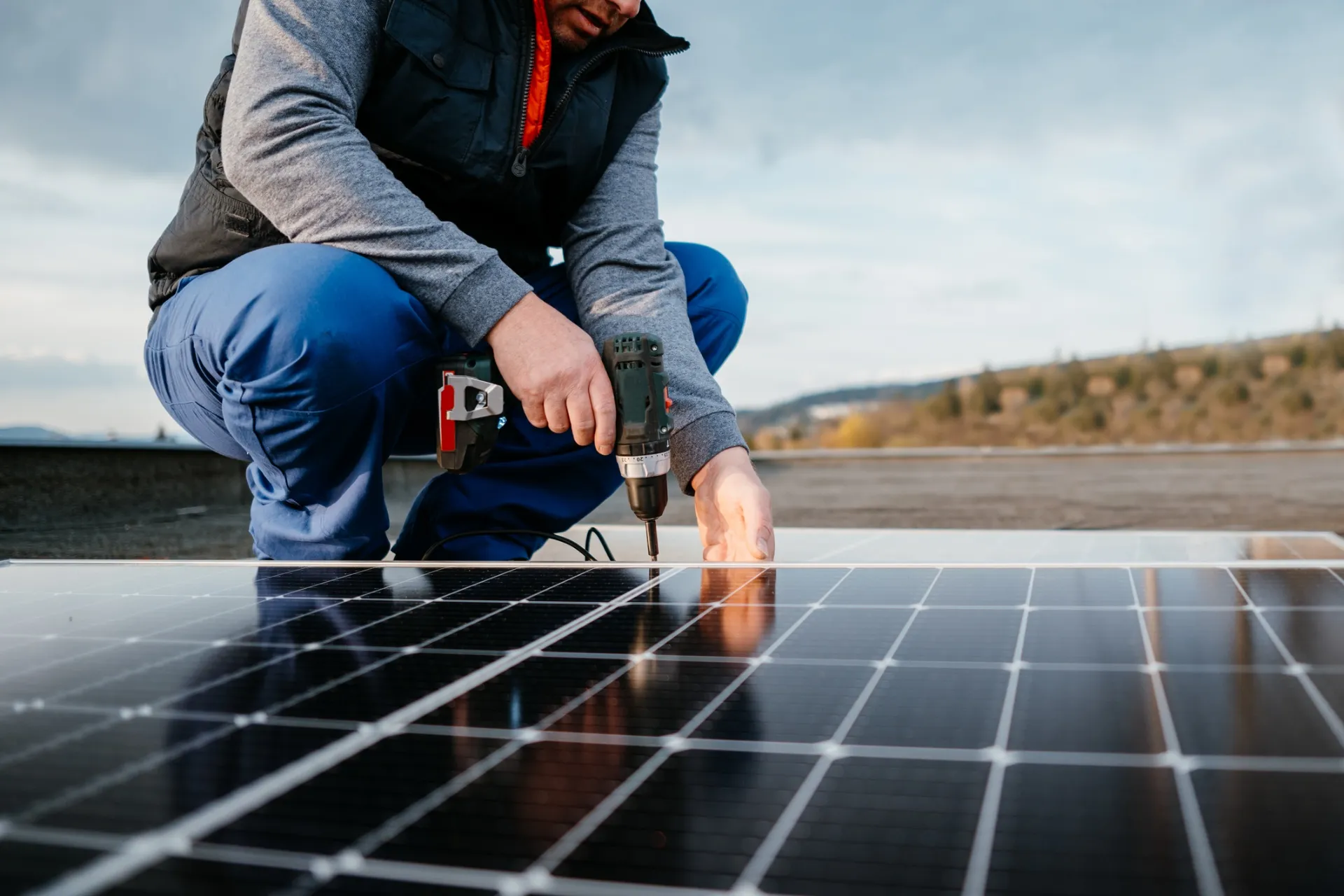 Nahaufnahme einer Fachkraft bei der Montage eines Solarmoduls auf einem Flachdach